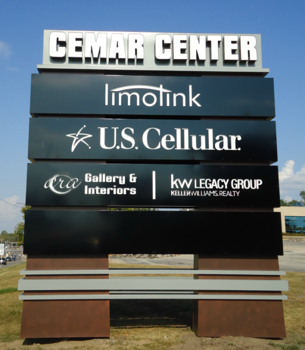 Outdoor sign for CEMAR CENTER displaying business names: Imolink, U.S. Cellular, era Gallery Interiors, and KW Legacy Group Keller Williams Realty.